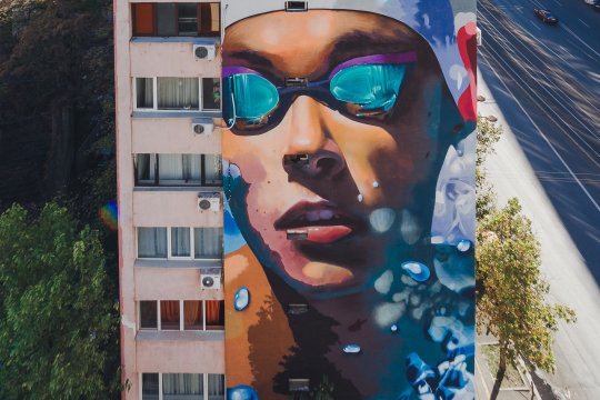 EXCLUSIV | Creatorii muralului cu Popovici: “Urmează Hagi, Patzaichin, doamna Lipă”. David a ales sloganul “Scrie-ți povestea prin sport!”