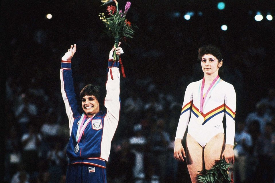 Mary Lou Retton, în prim plan, cu medalia de aur și Ecaterina Szabo cu medalia de argintat, pe podiumul de premiere al concursului de gimnastică indivisual compus, Jocurile Olimpice de vară 1984 Los Angeles, Caliornia, 5 august 1984.