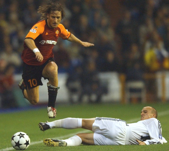 Francesco Totti stânga, trece de Esteban Cambiasso, la pământ, în meciul dintre Roma și Real Madrid, din 2002