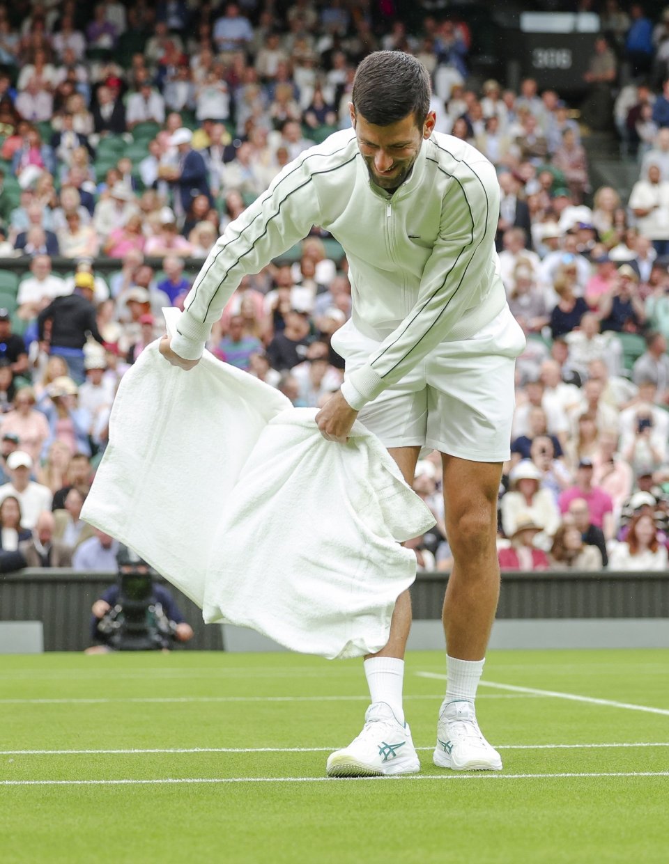 Novak Djokovic usucă gazonul de la Wimbledon