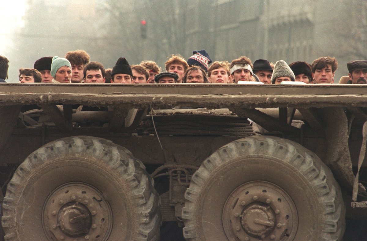 Cetățeni care urmăreau lupta dintre Securitate și Armată la Revoluție